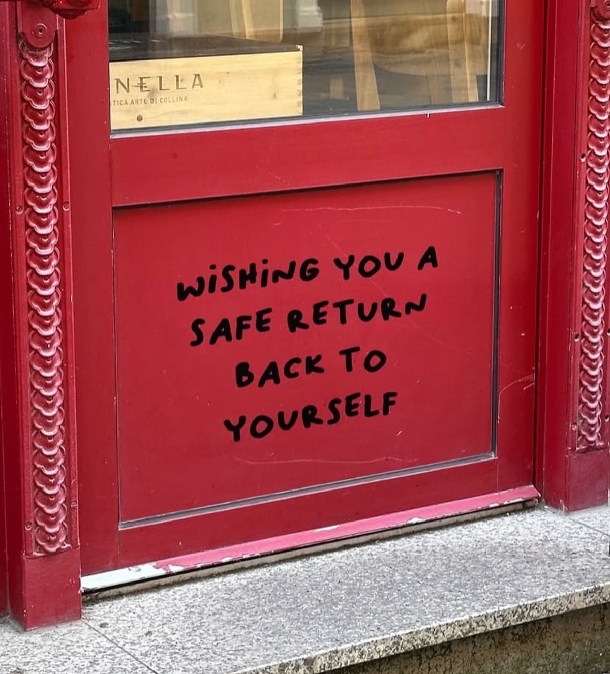 A red doorway with a reminder about returning to yourself
